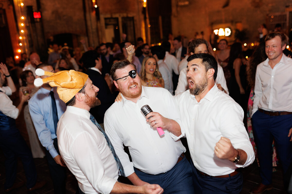 Guests celebrating on the dance floor beneath moody lighting at Basilica Hudson.

