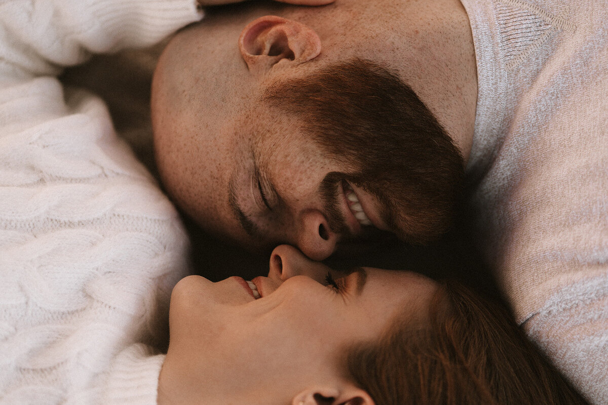 Couple lying down with noses touching