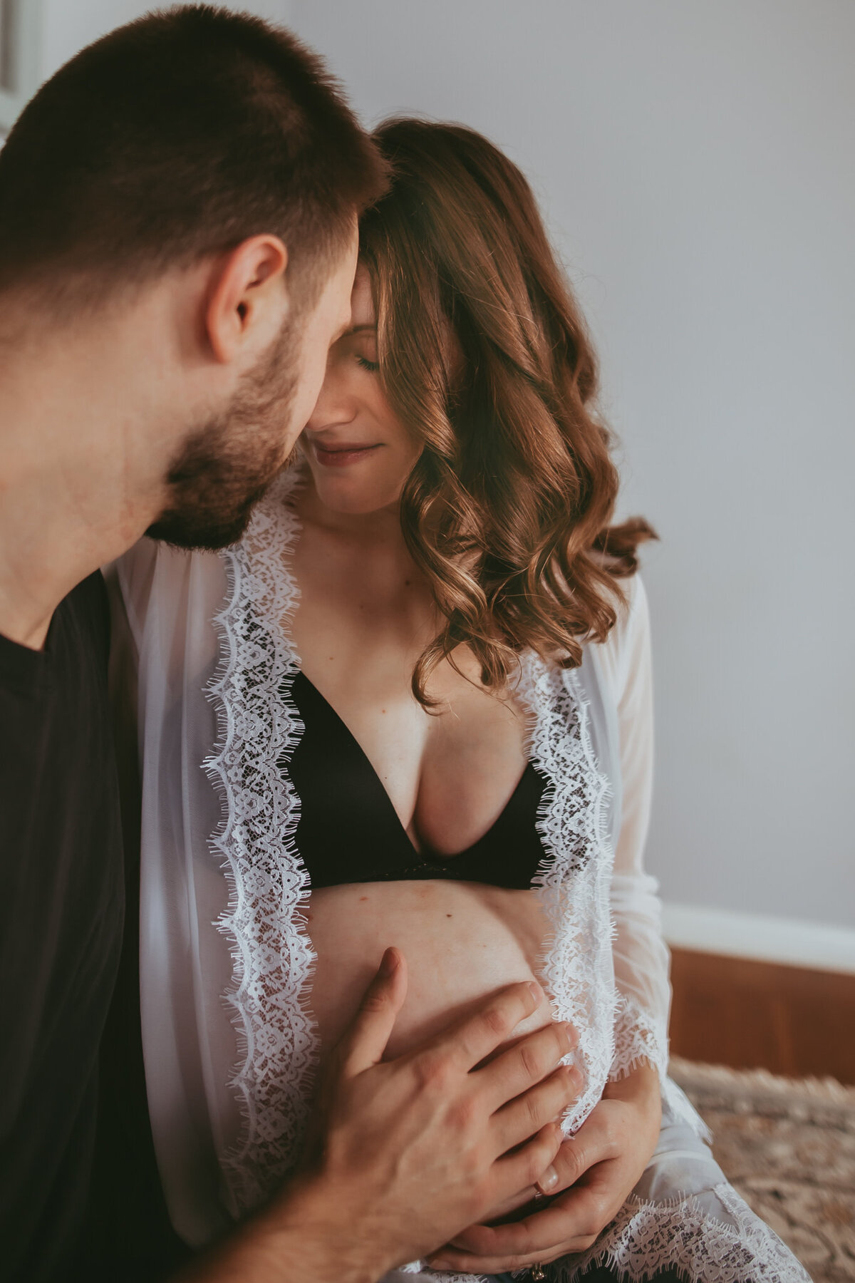 pregnant couple snuggles
