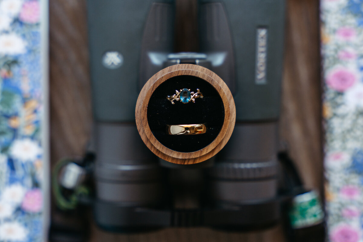 Flatlay of groom’s details with floral bow tie and stationery