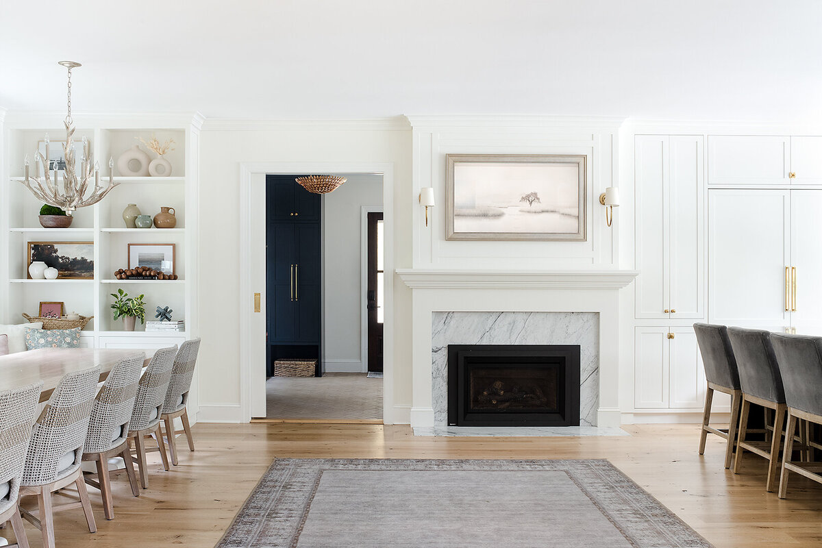 white living room with fireplace and archway to dark blue room