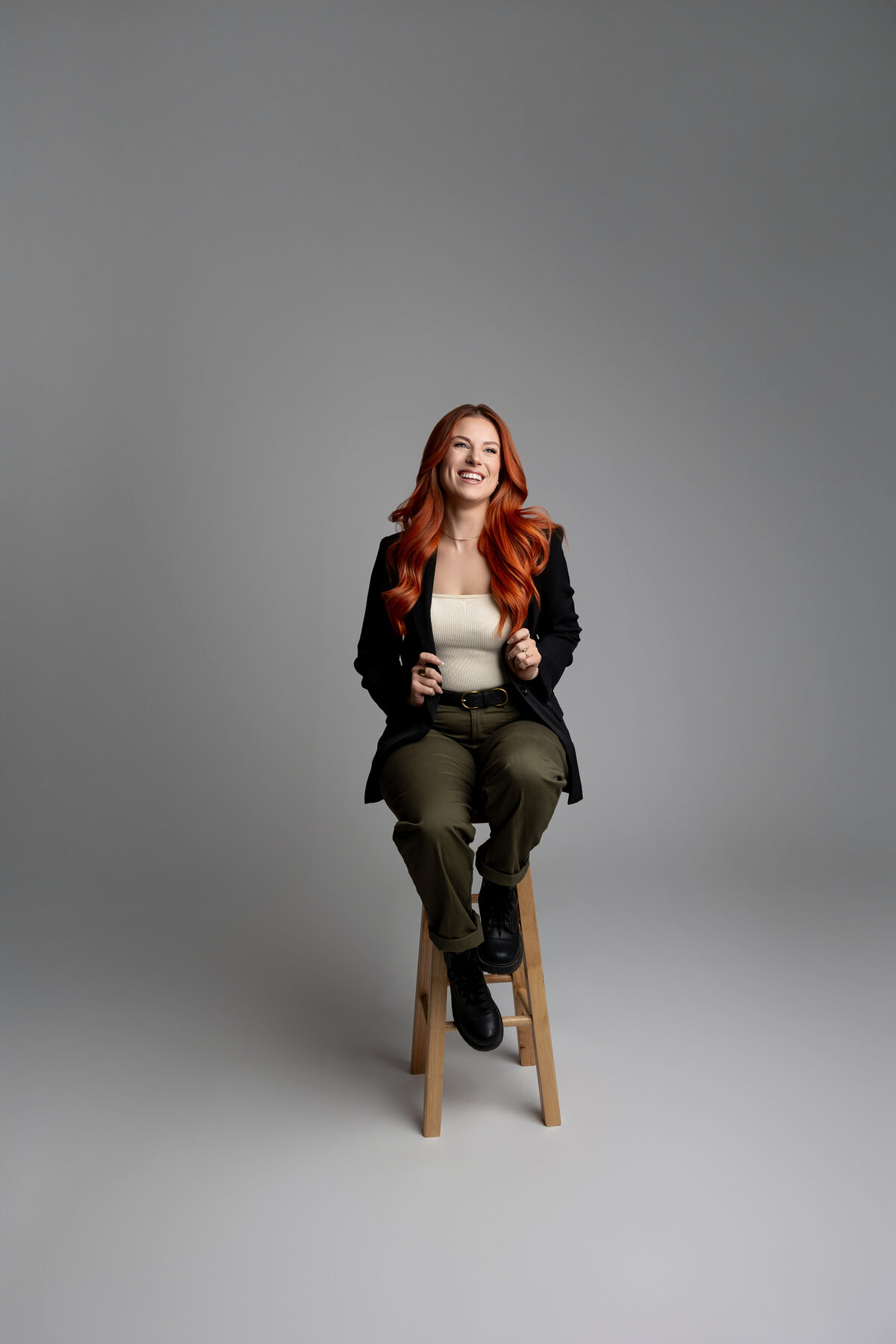 Full-length portrait of red-haired woman standing in black blazer and green pants. Photograph by Yucaipa branding photographer Kaitlyn Dawn Photography.