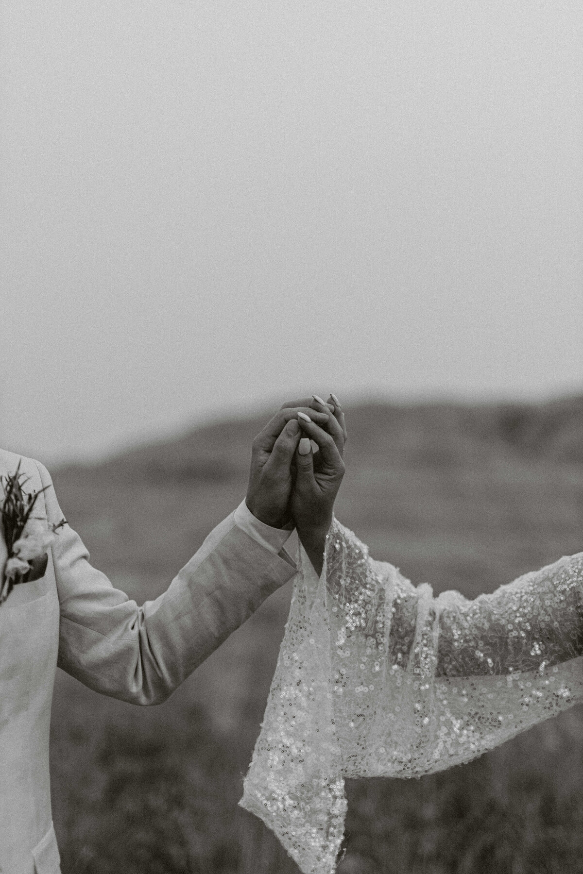 Couple holding hands during their Alaska elopement in black and white 