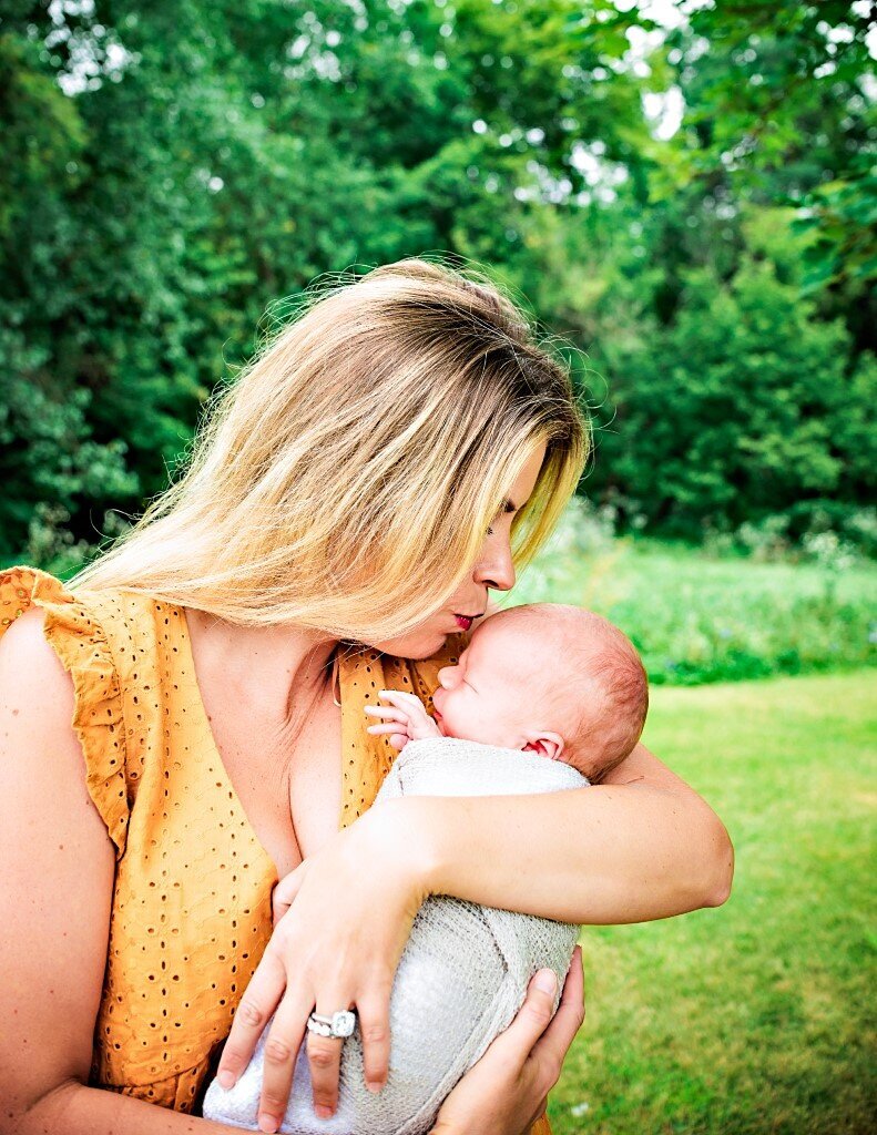 mom holding and kissing newbonr