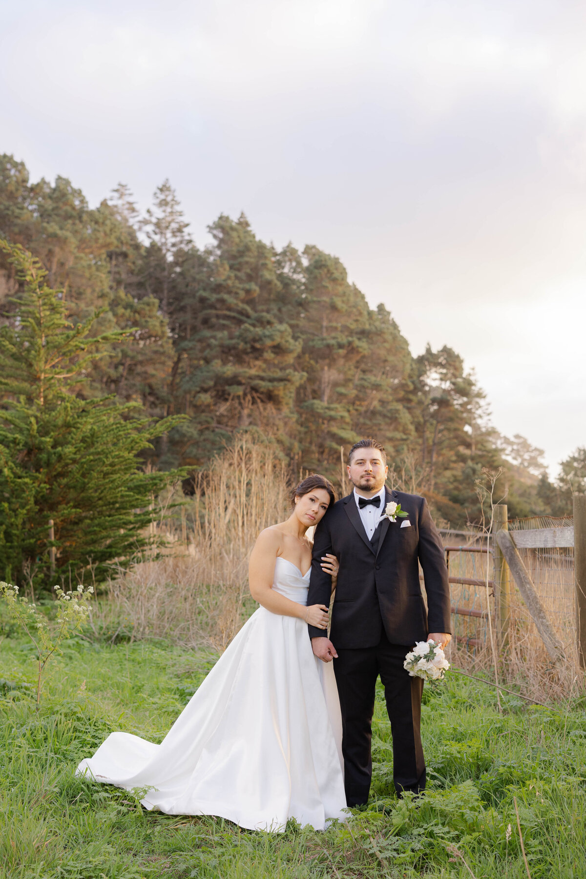 Bride and Groom standing next to each other during sunset hour photos