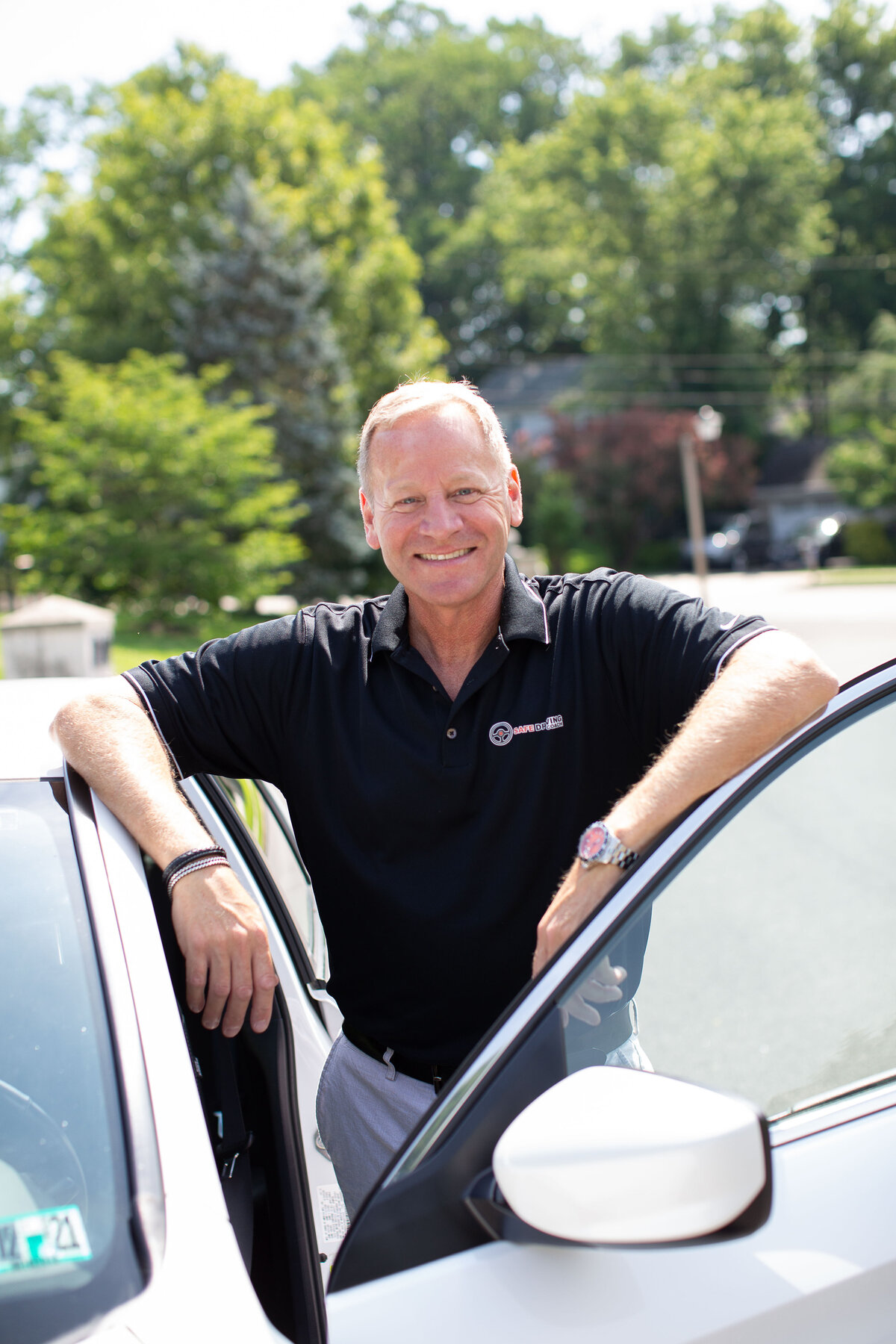 Driving coach standing in open car door