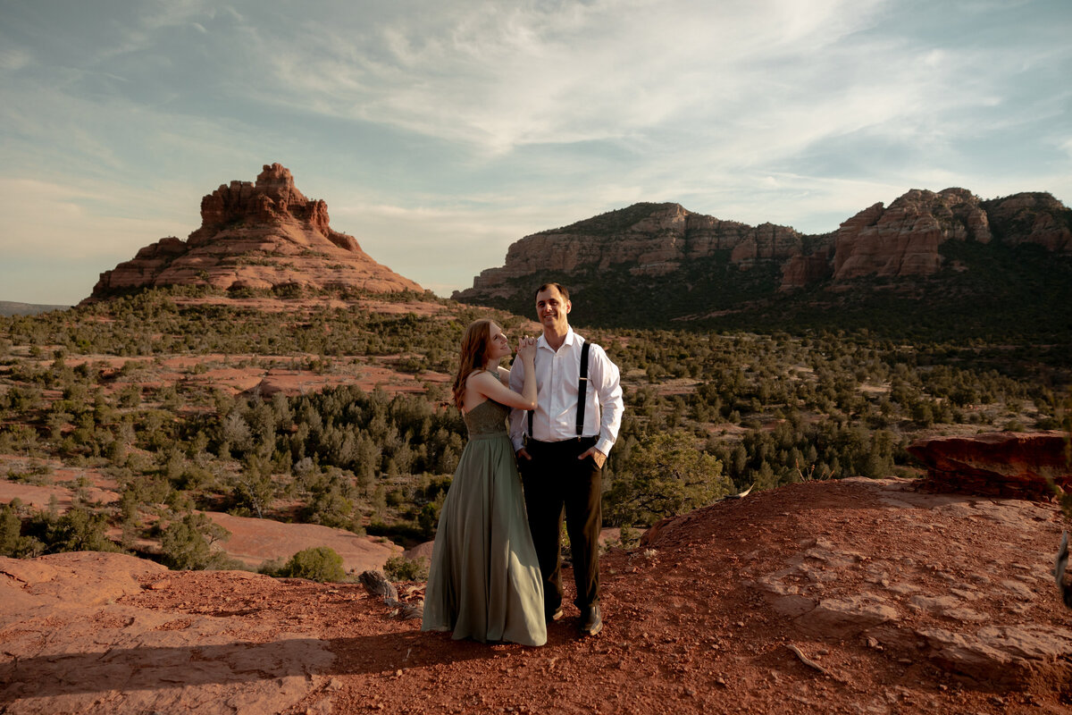 Couple standing against red rock backdrop during Sedona engagement session