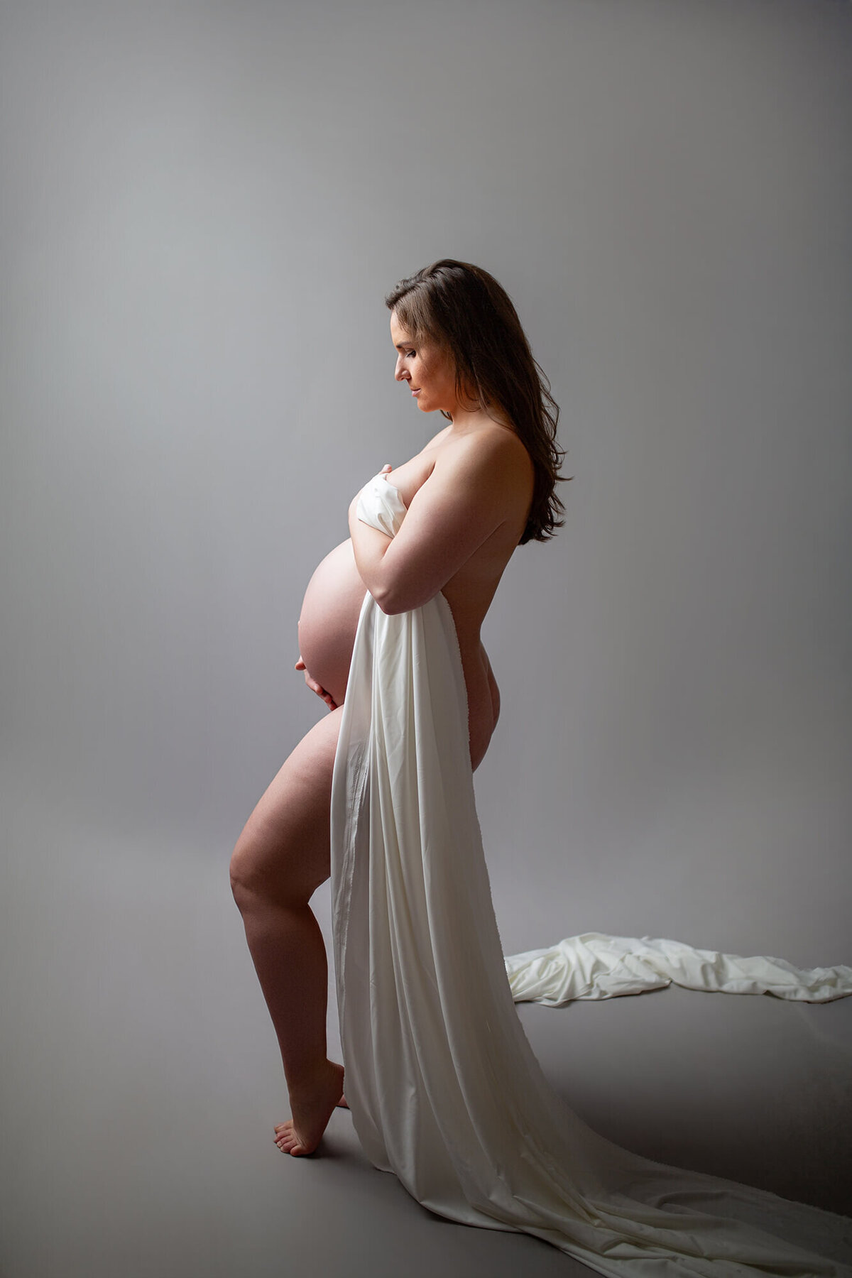 Simple and modernistic maternity shoot with fabric draped around woman