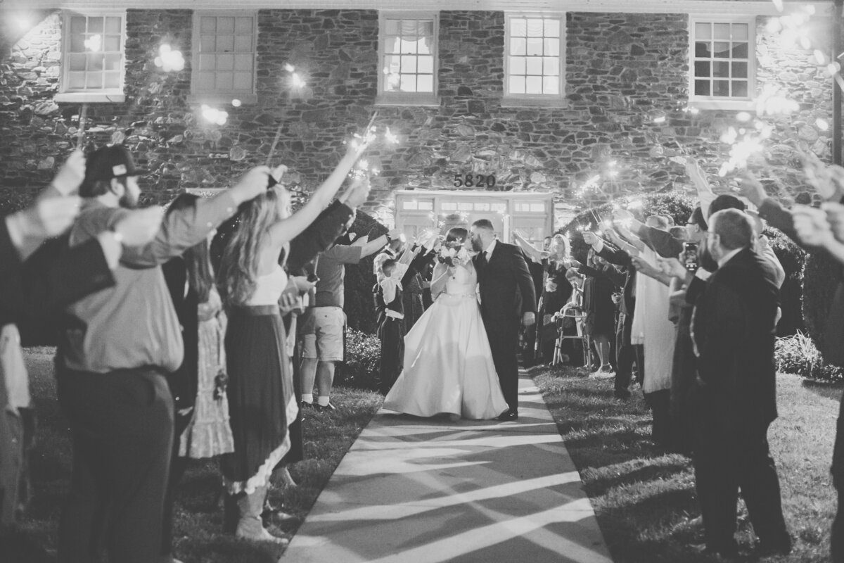 Bride and groom exiting under sparklers surrounded by cheering guests at New Bern North Carolina wedding.