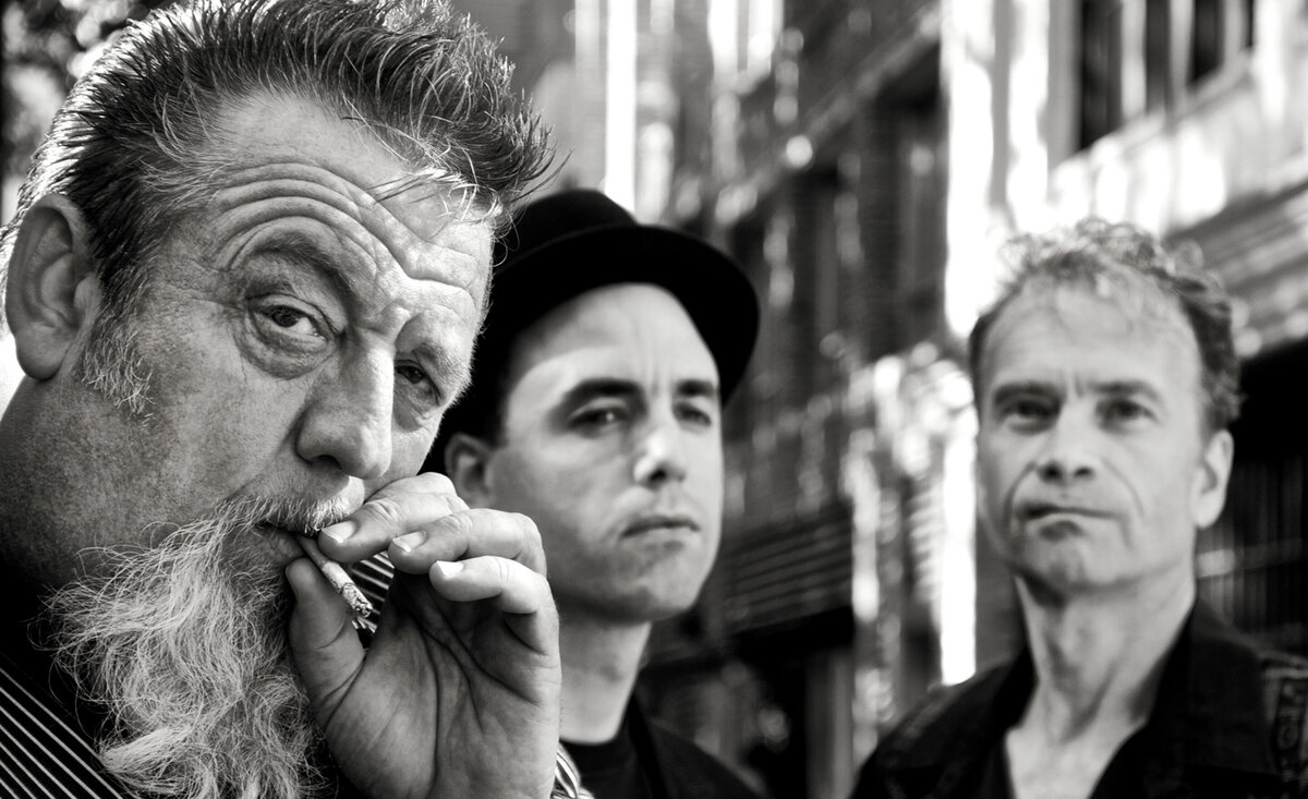 Musical trio portrait Travelin Blues Band black and white close up member left side smoking cigarette