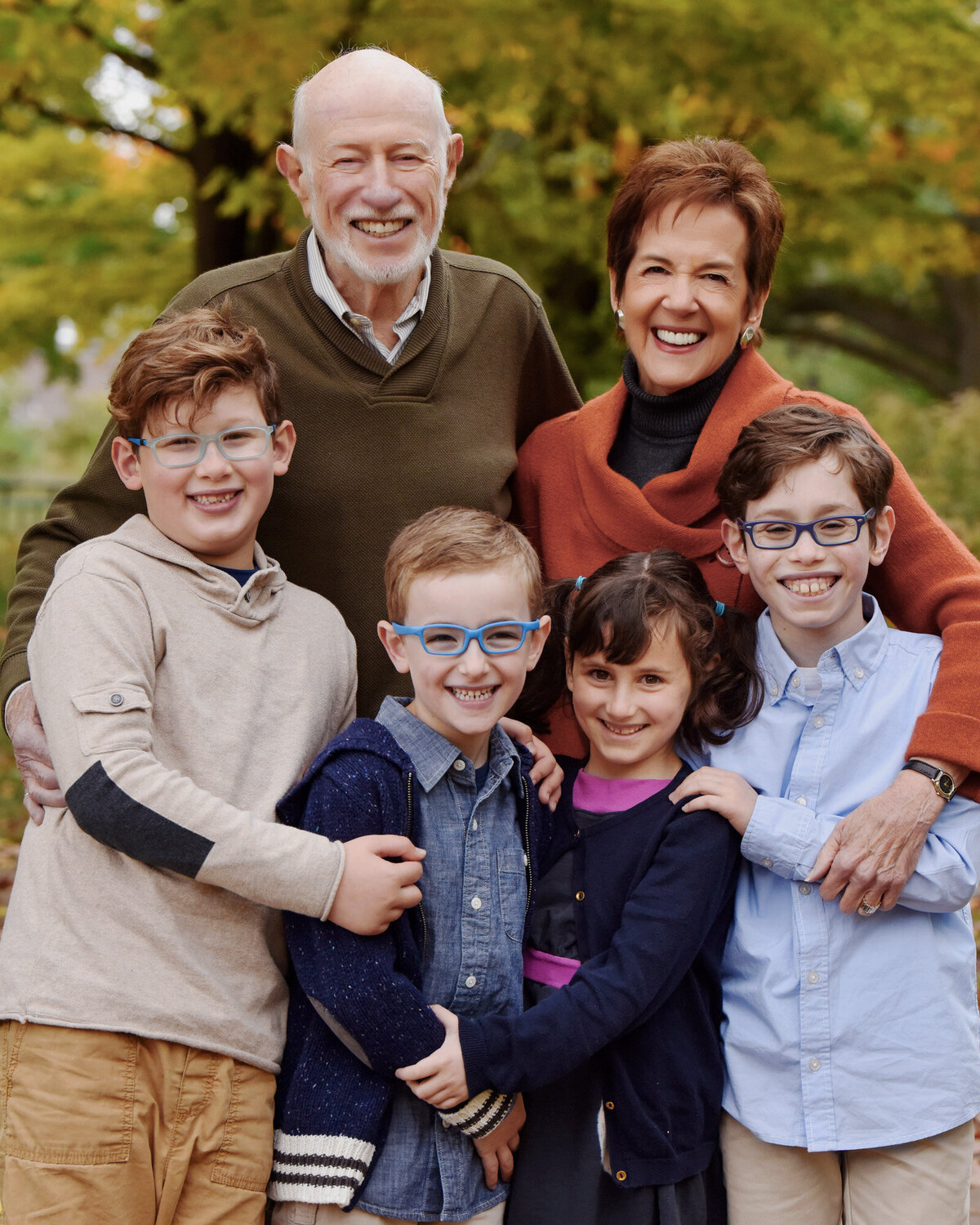 Grandparents hugging grandchildren outdoors fall photo