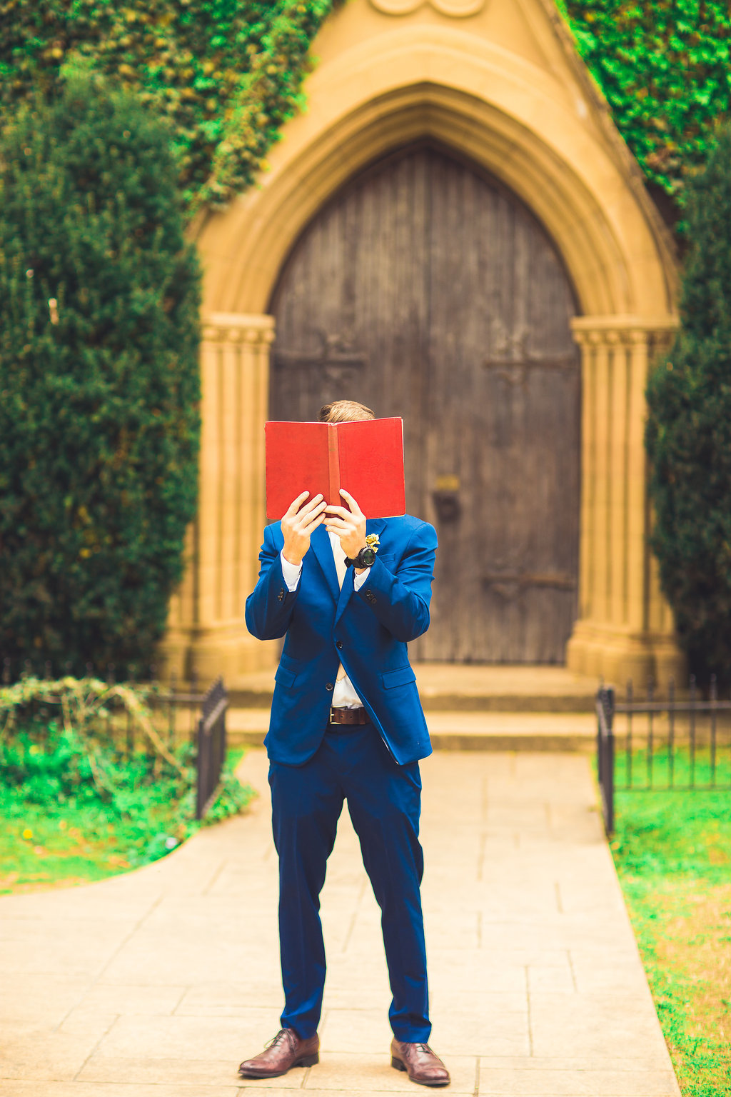 Wedding Photograph Of Man in Blue Suit Covering His Face With a Book Los Angeles