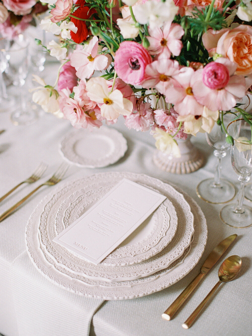 elegant and romantic wedding table setting with luxury tableware and red bold flowers