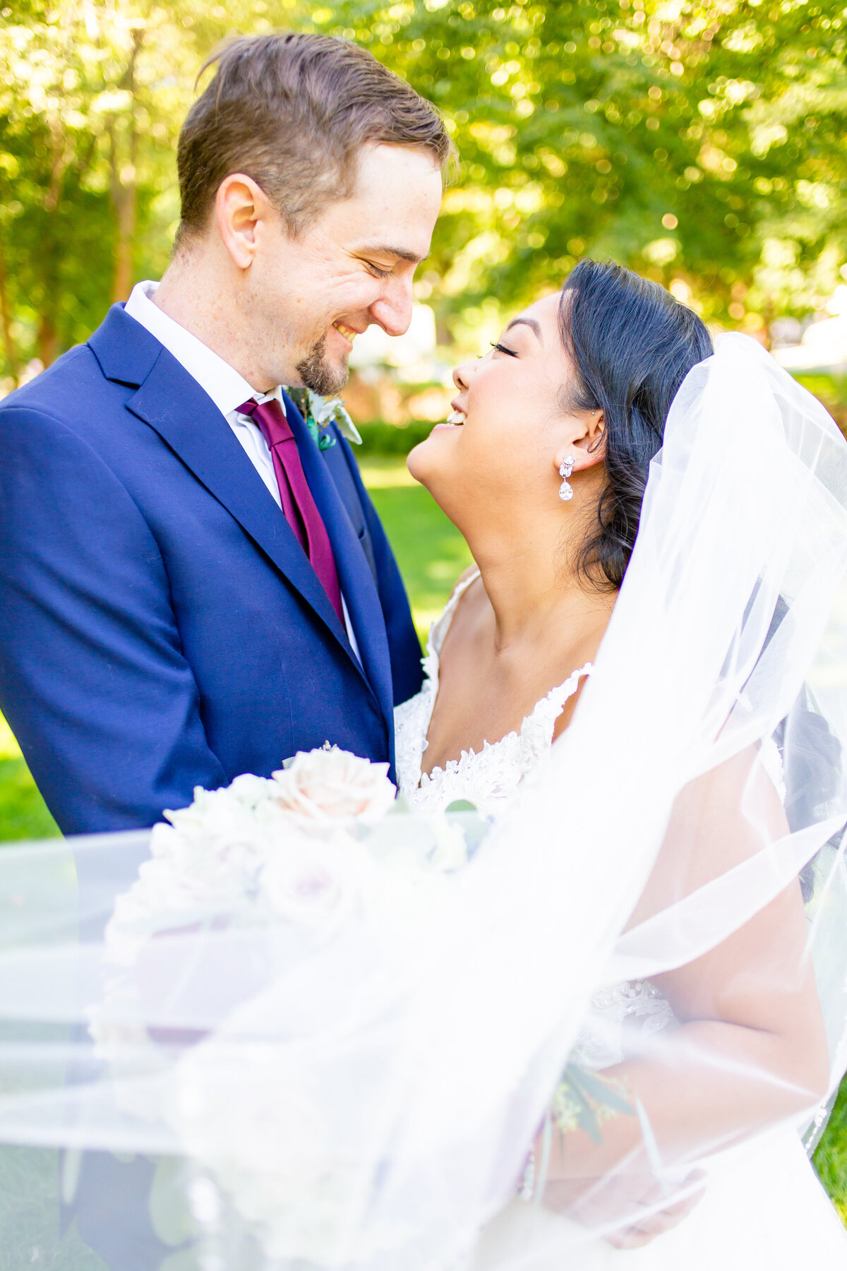 Bride and groom gazing into each others eyes as the brides veil sweeps in front of them