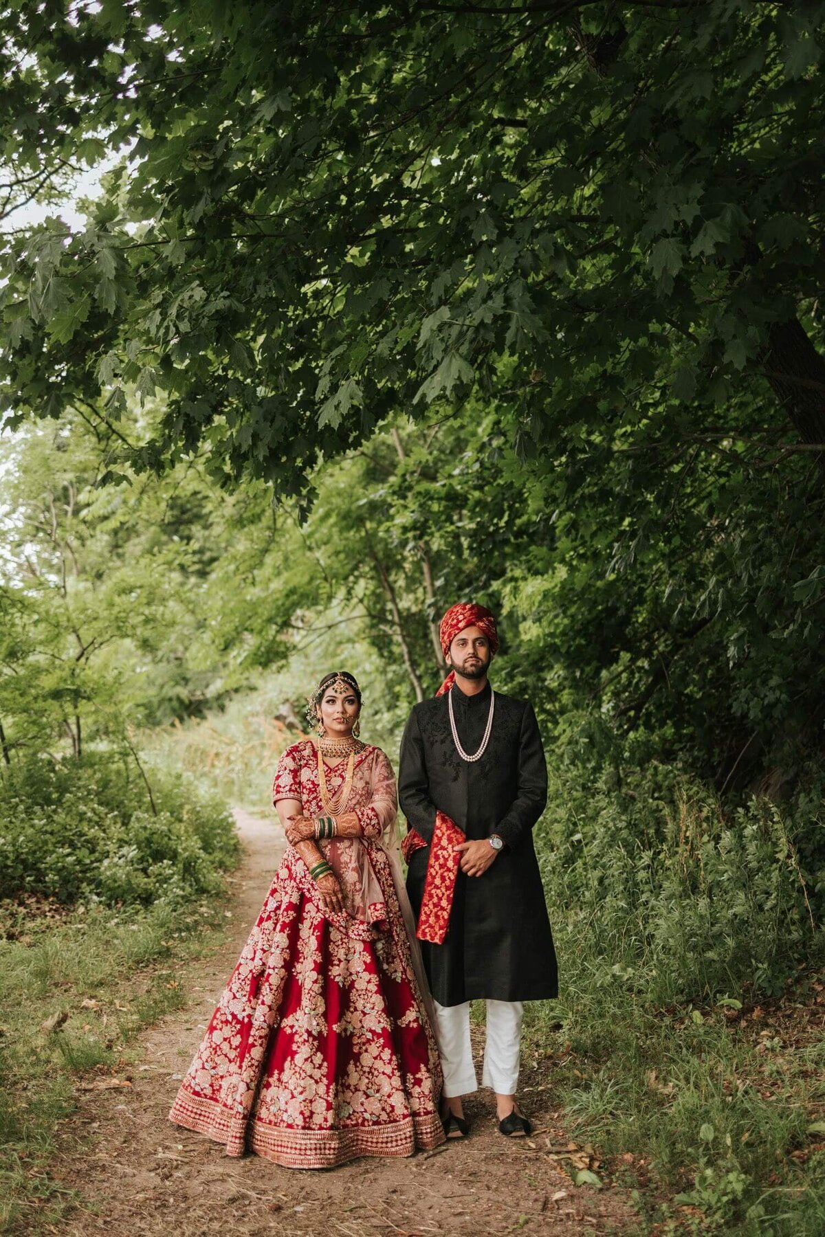 South Asian bride and groom walking on a trail together surrounded by greenery in Philadelphia taking a moment to themselves.