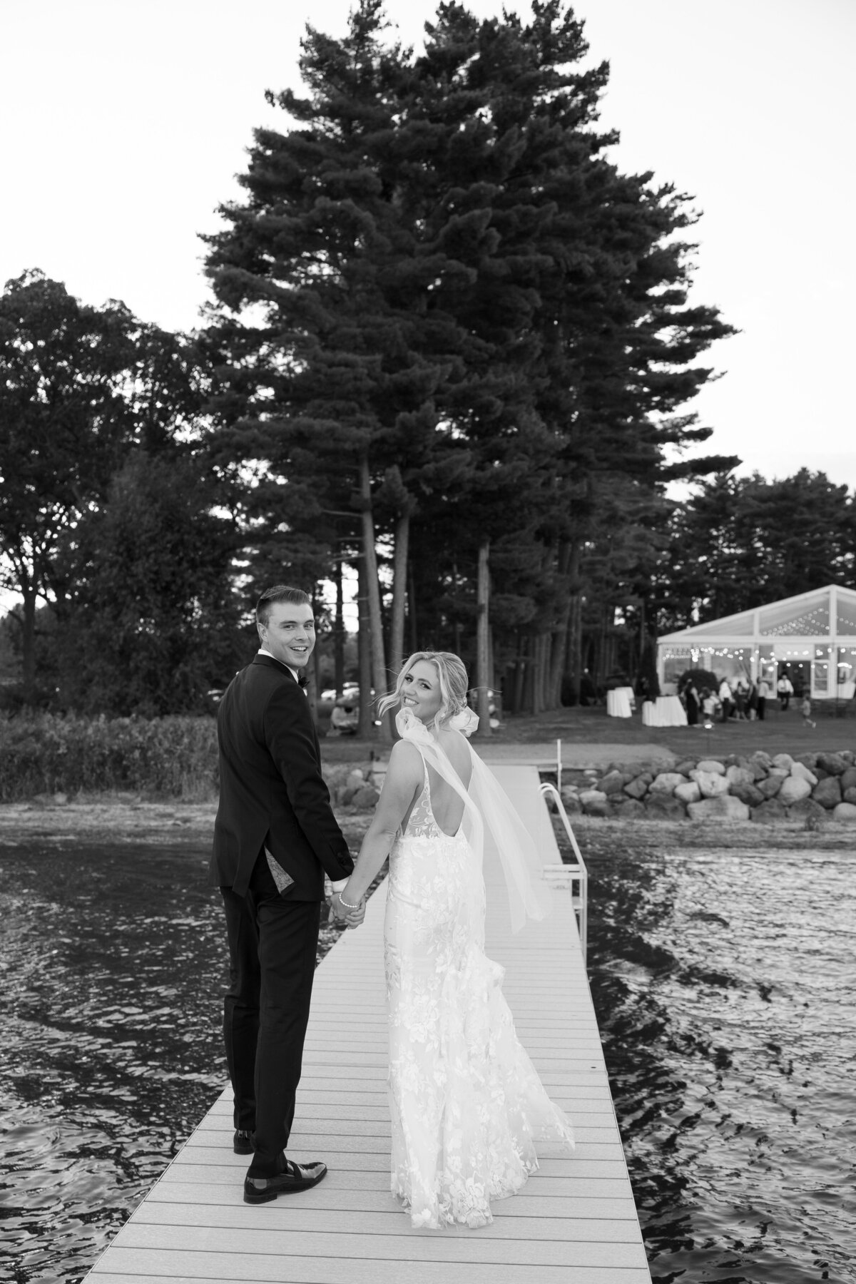 A wide shot of the couple on the pier, framed by Lake Mendota’s sparkling water and lush gardens.