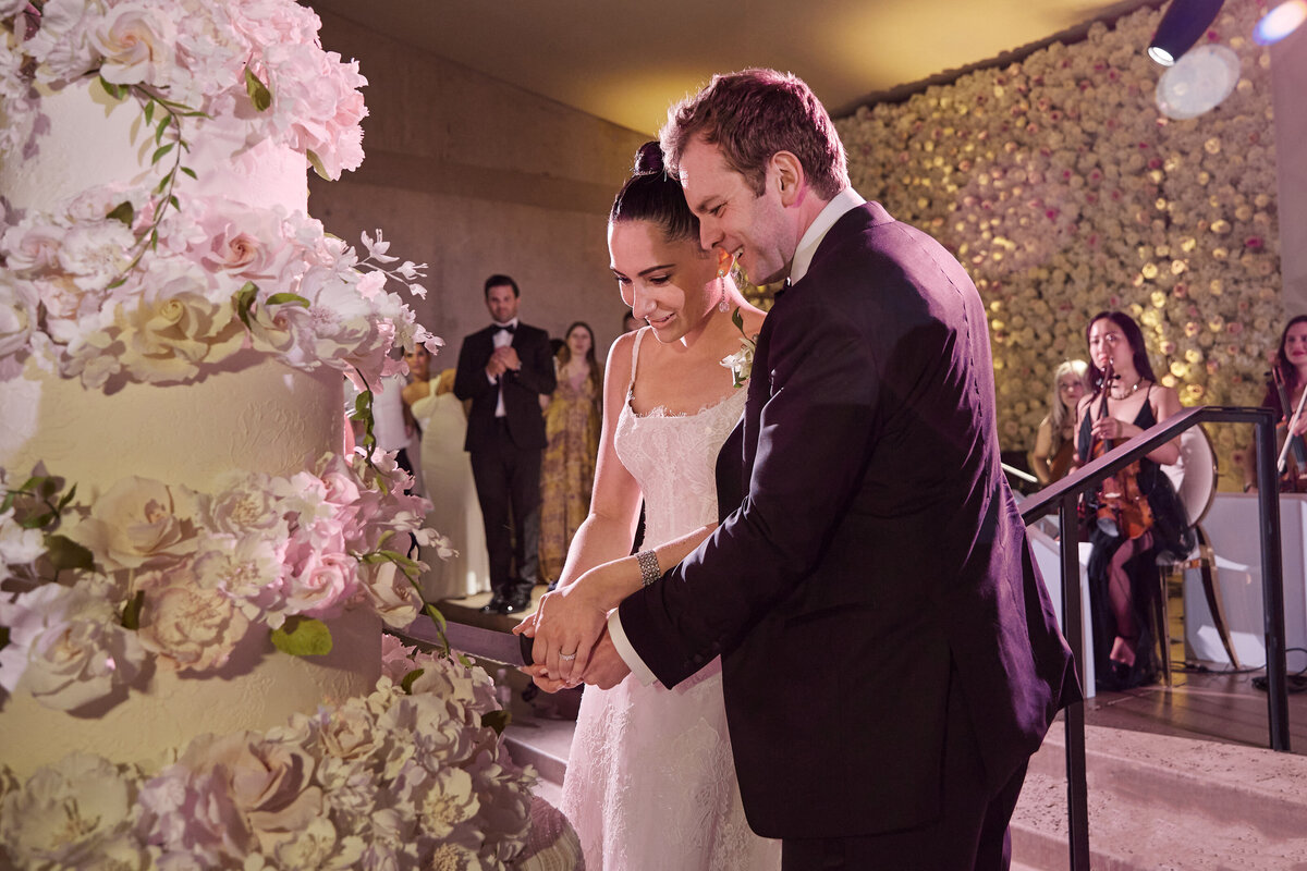 Newly wed bride and groom cuttting the cake at their wedding at Amangiri UTah