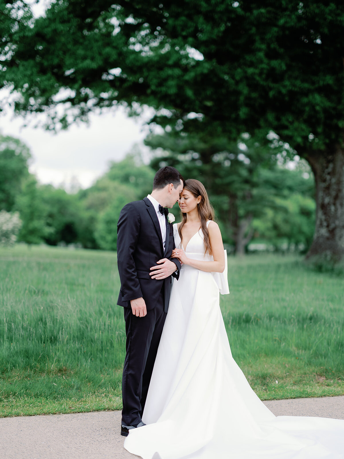 Bride and groom close eyes for a classic portrait on the path of the course at congressional country club