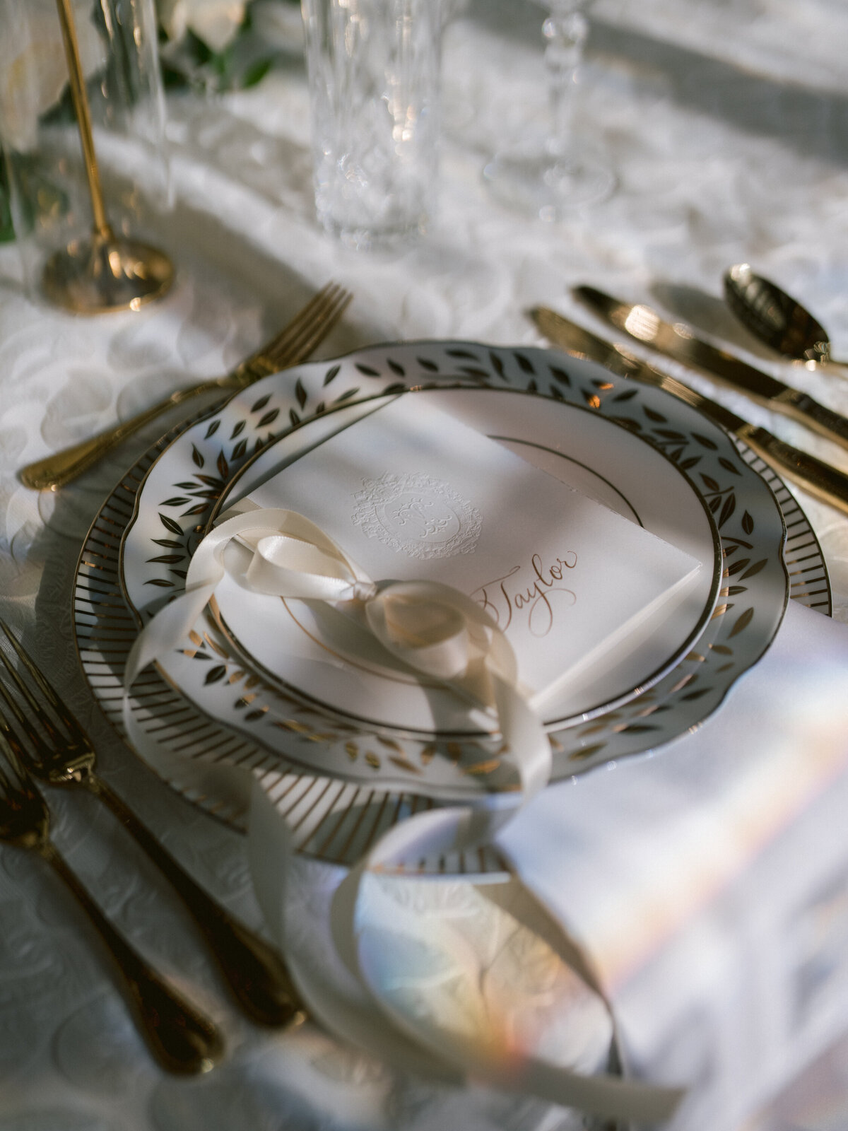 gold callligraphy on white debossed menu card with white ribbon