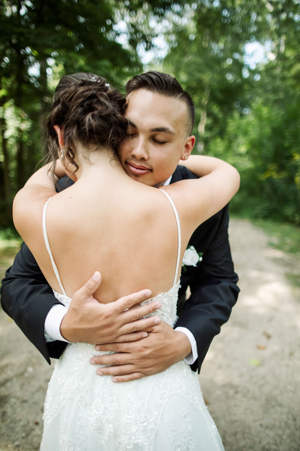 Bride and groom hugging each other in an outdoor setting