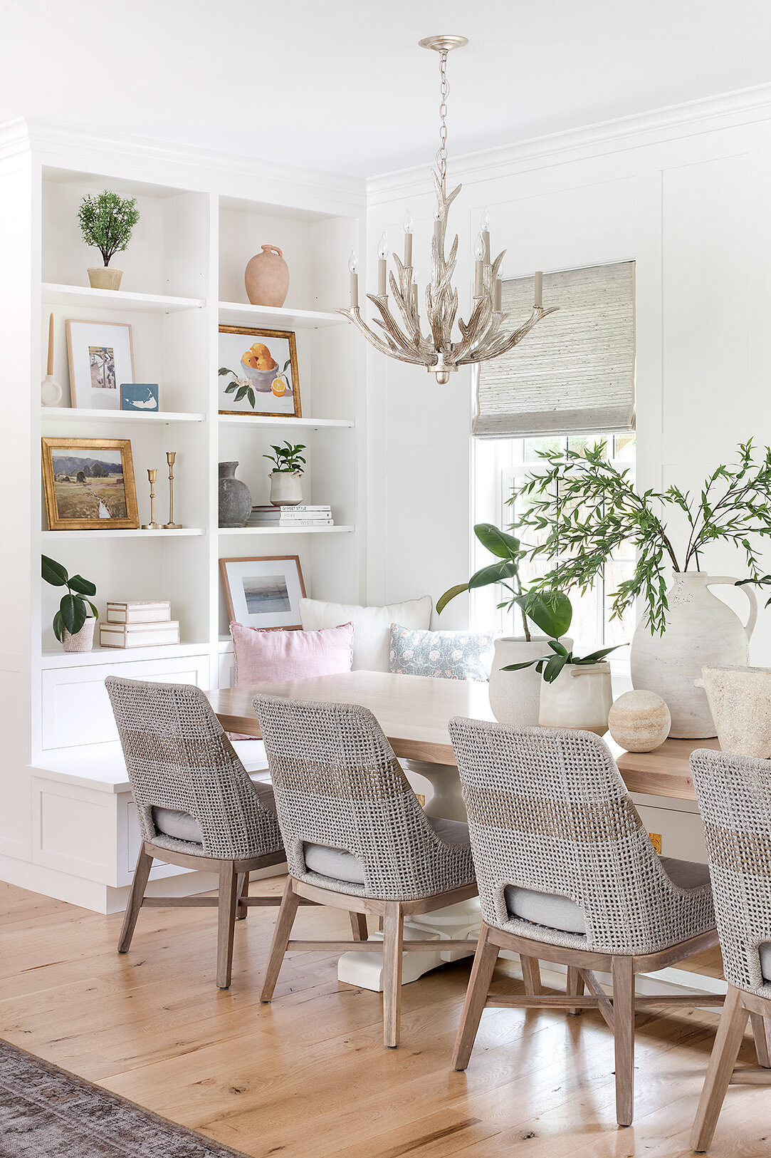 white and tan dining table with open shelves and window corner bench