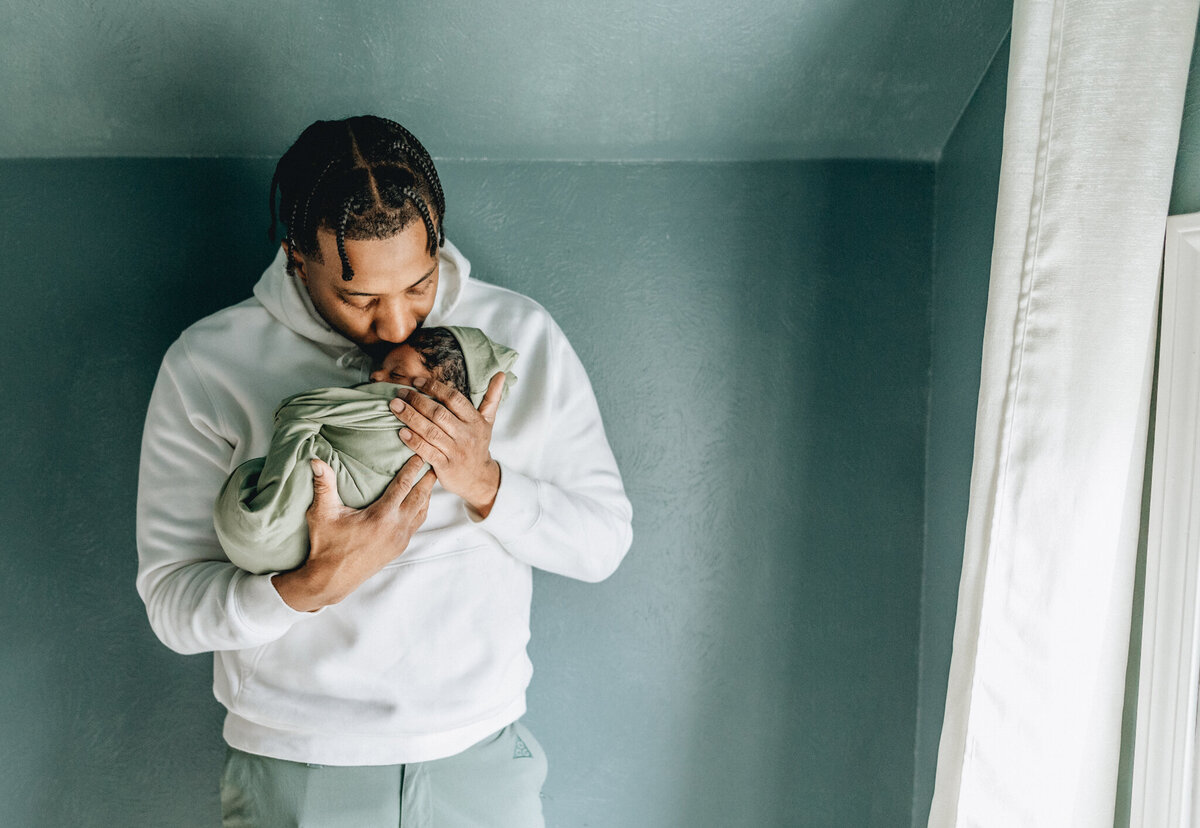 Family photography of dad holding newborn baby