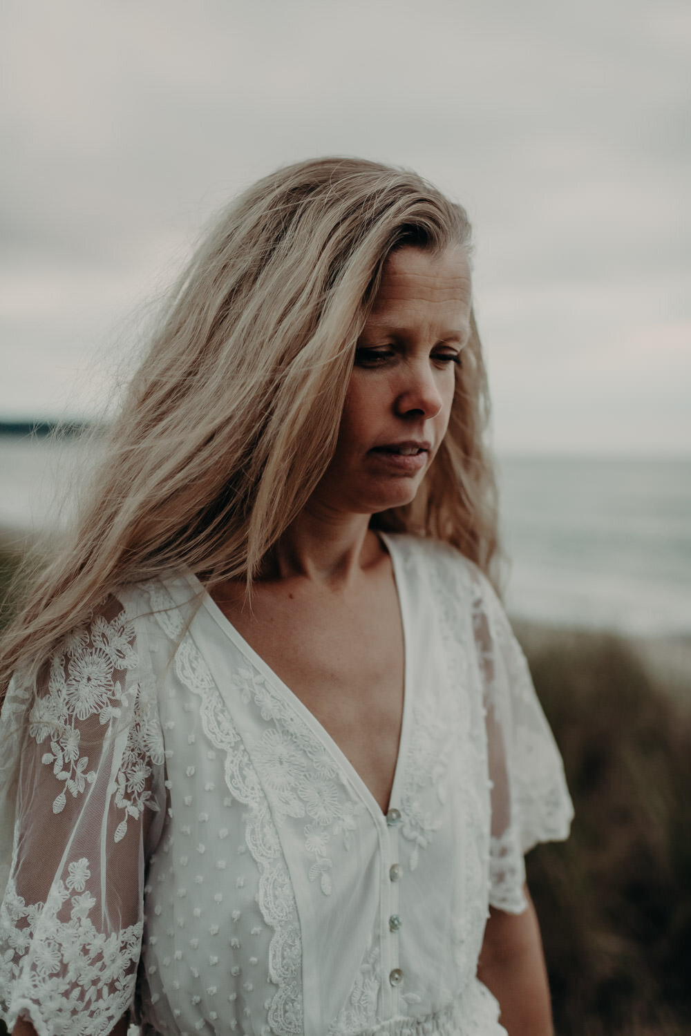 A boho bride walking on the beach during her elopement