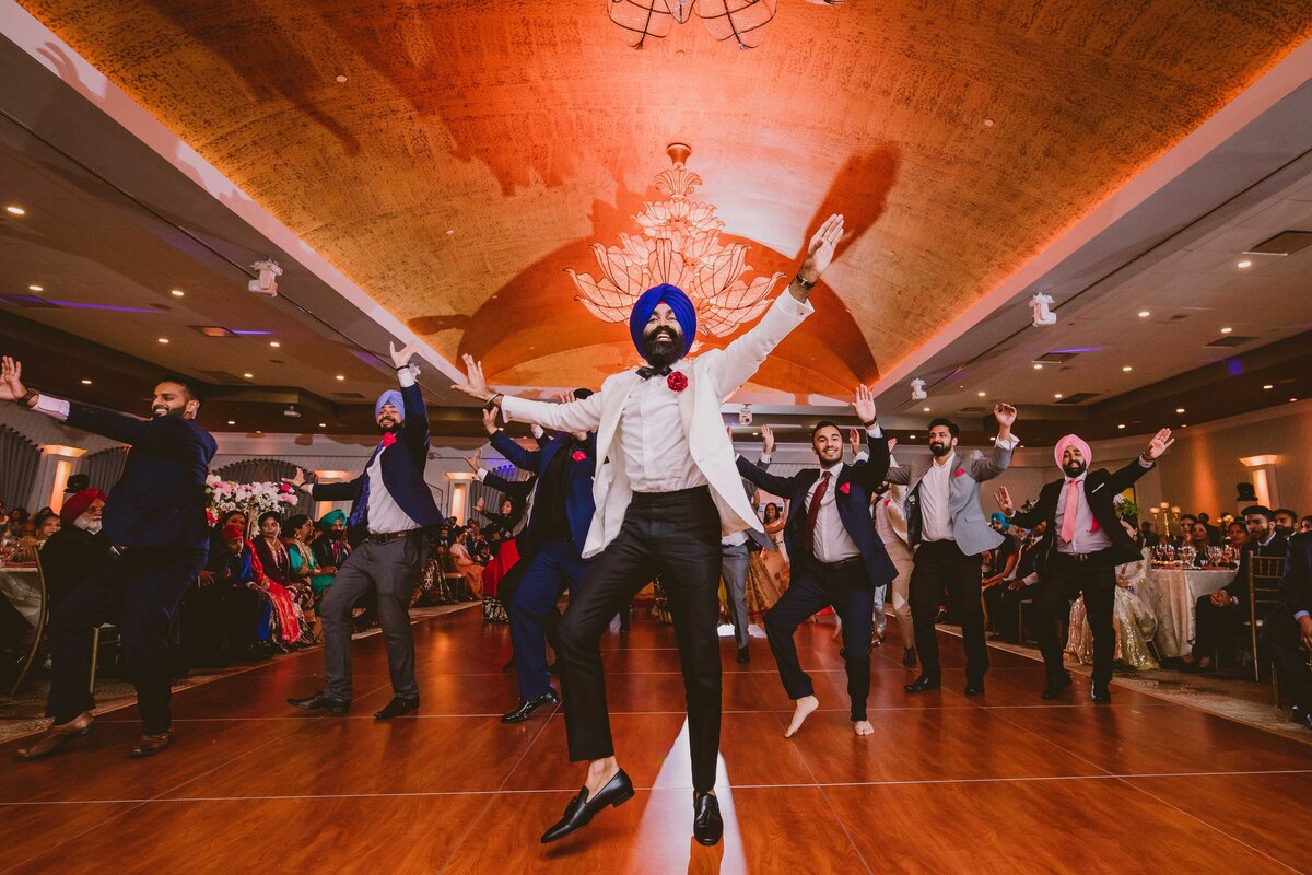 indian sikh groom performing dance at the wedding reception in marigold nj