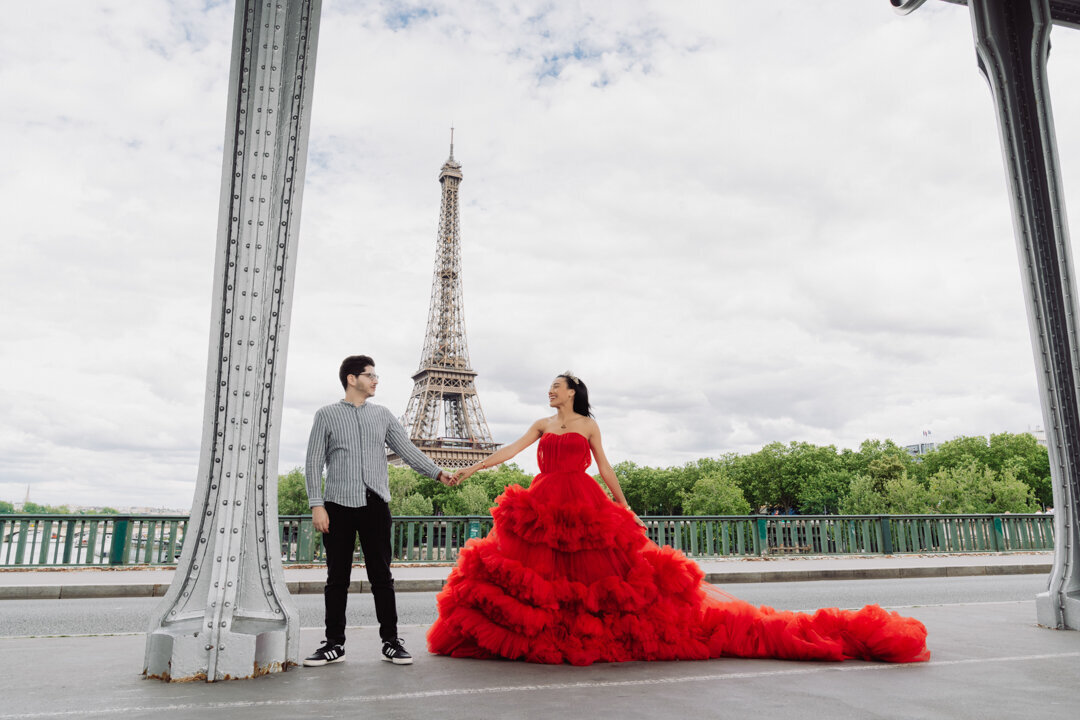 Bir Hakeim Bridge couple session, red princess dress, hand holding pose, Eiffel Tower view