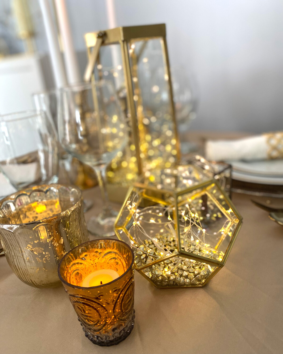 A side view of an elegant tablescape featuring gold and white china, delicate linens, and a sophisticated centerpiece, designed by In Full Bloom Event Planning & Design