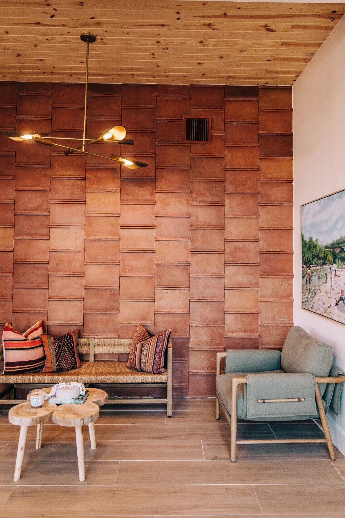 Sitting area in bar with wooden coffee table, wooden ceiling, gold lighting and seats