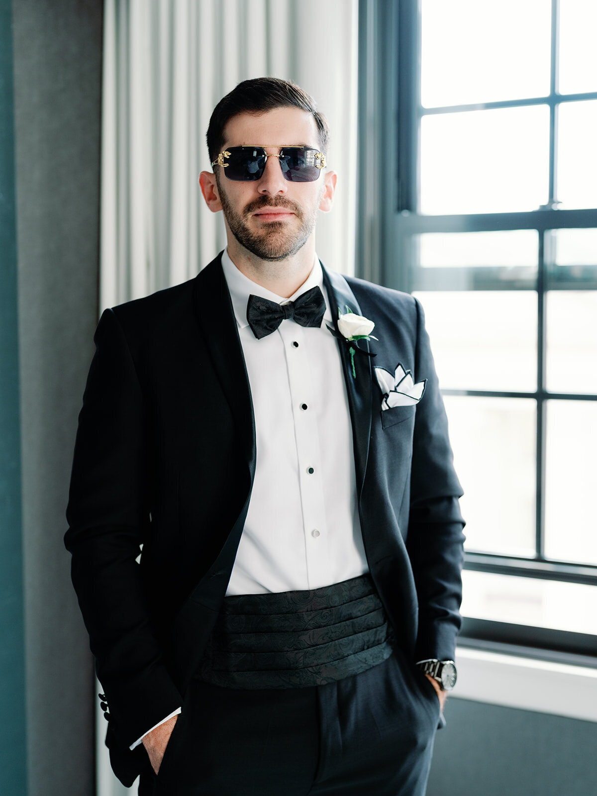 Groom poses for portrait wearing sunglasses at Hotel Washington 