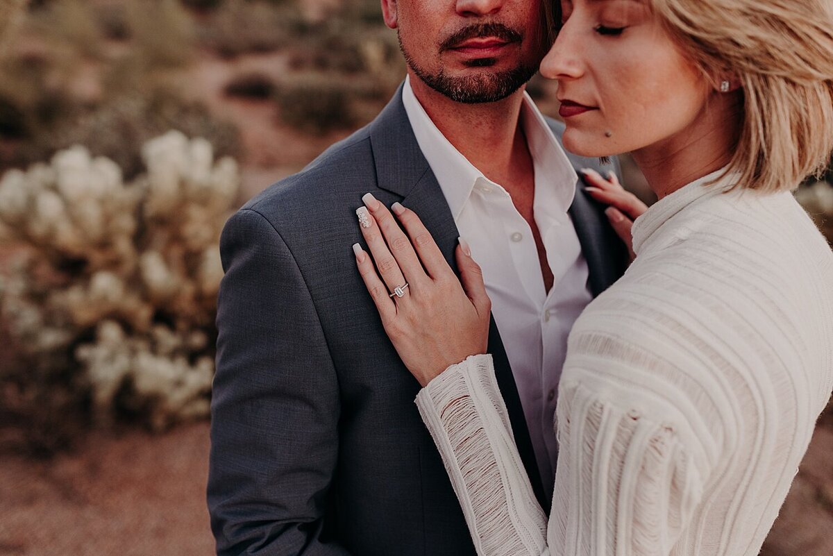 couple cuddle in front of the superstition mountains