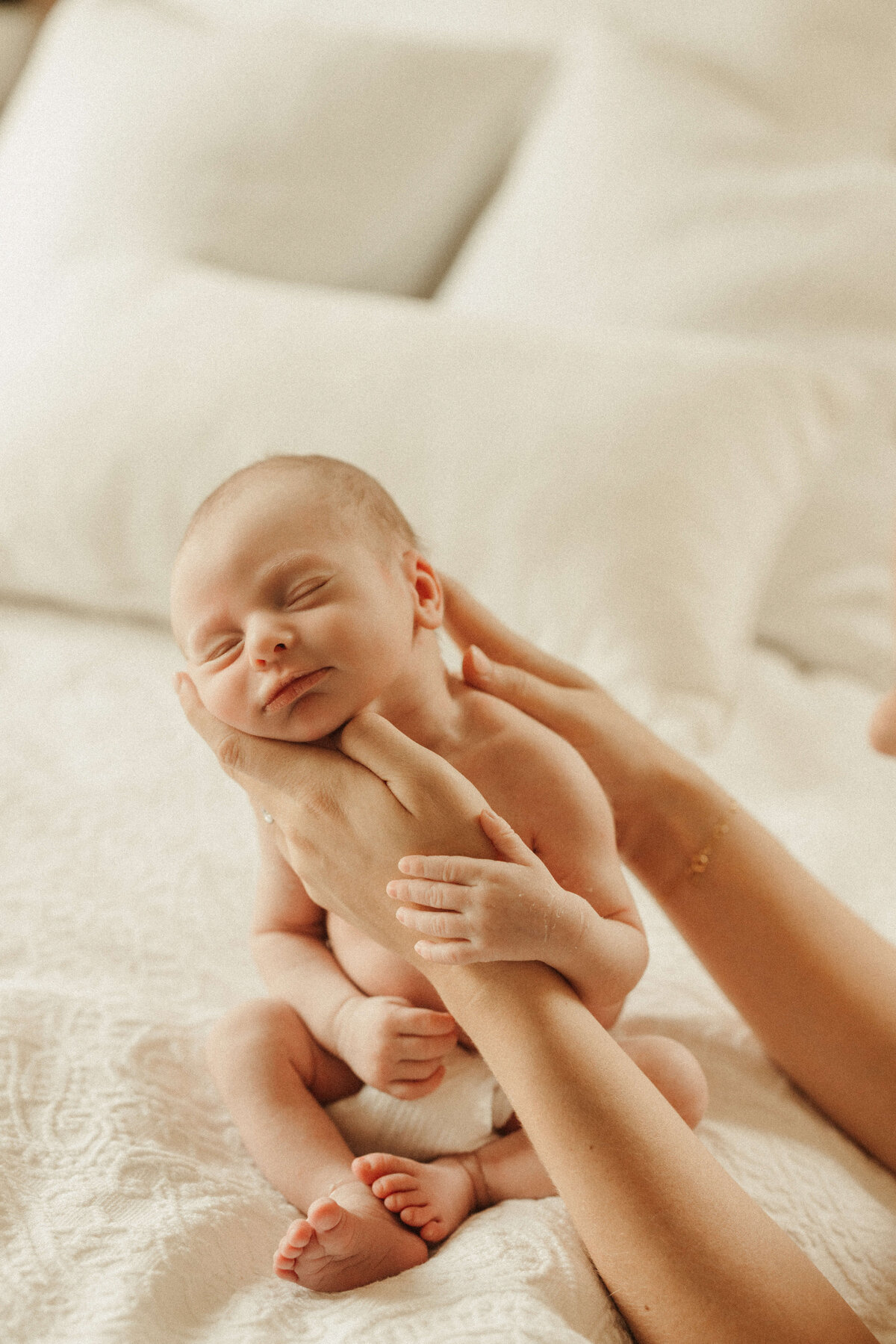 Newborn lying on bed during cozy in-home photography session in Franklin TN
