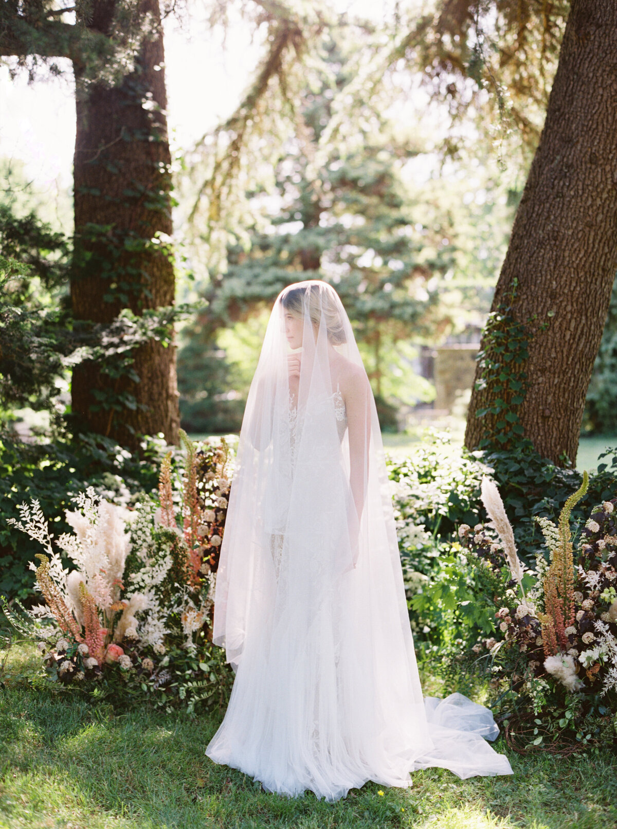 Bride with veil over her face standing by flowers in Los Angeles