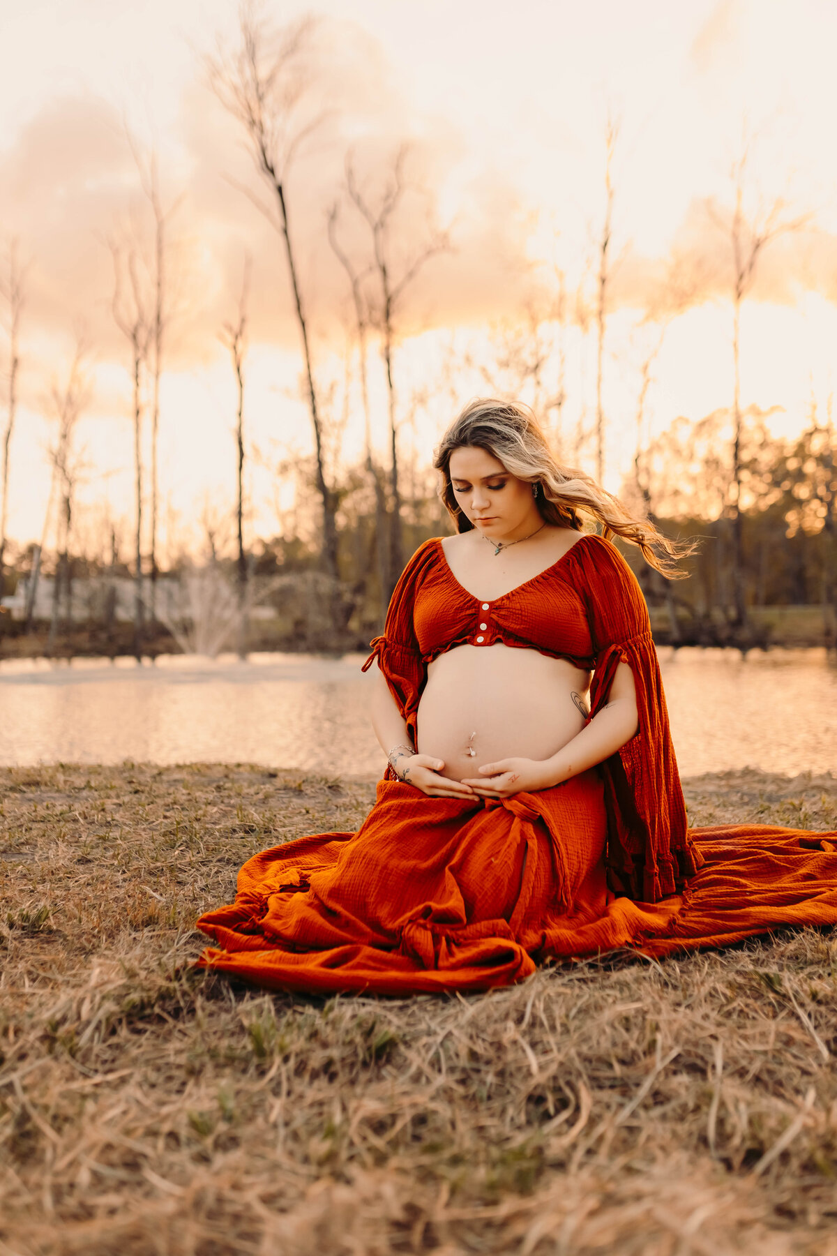 Maternity session in Tarkington TX - expecting mother showing baby bump in burnt orange dress