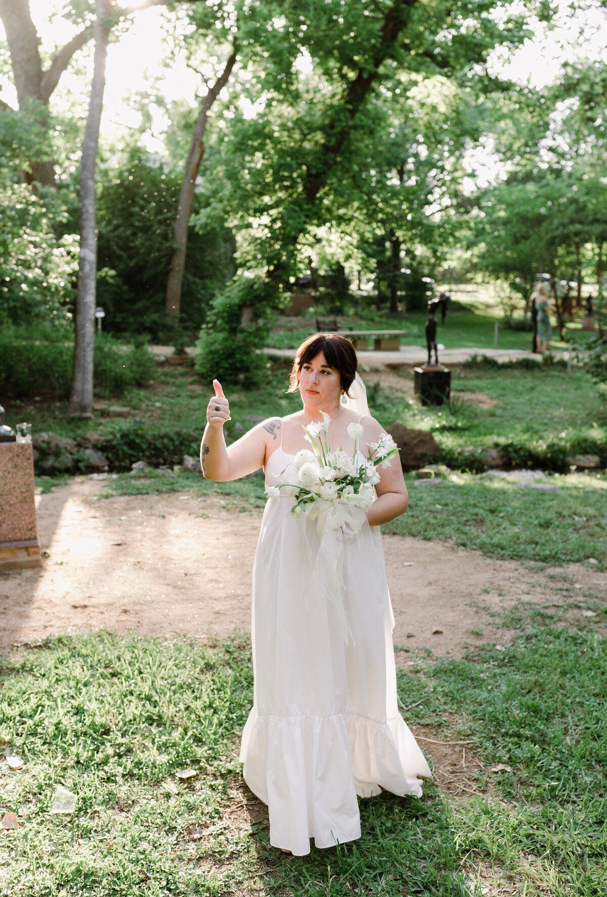 Bride making thumbs up at Umlauf Sculpture Garden, Austin