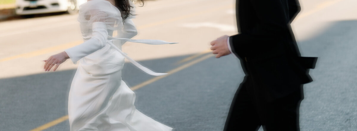 Bride and groom run across the street