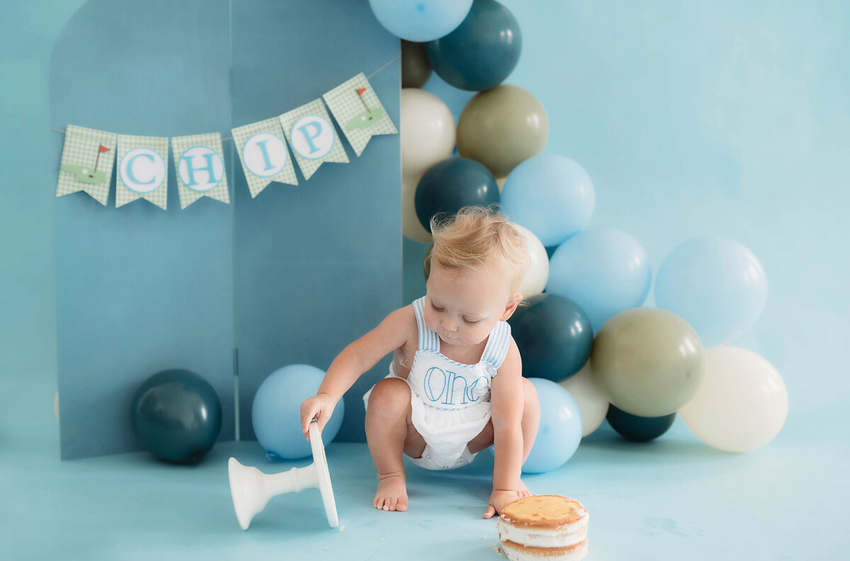 Baby knocks over cake during Cake Smash Photos in Charleston.
