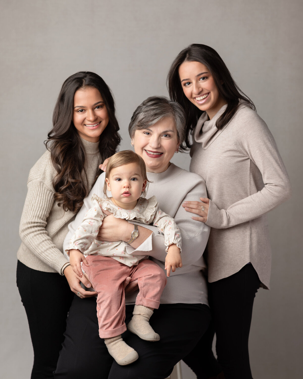 grandma and three granddaughters posing for studio portraits