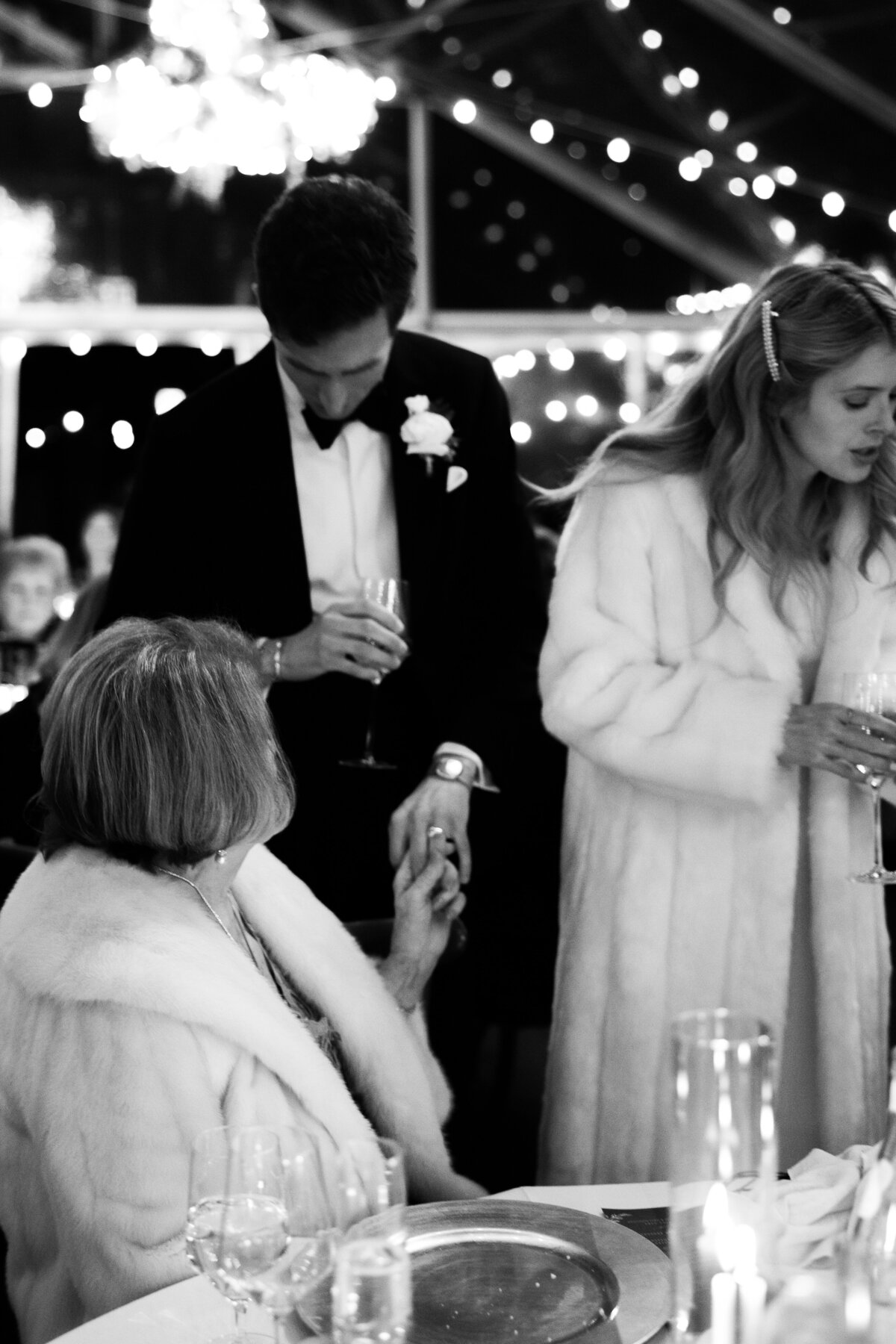 Black and white photo of the groom showing off his ring to his grandmother, captured in a candid wedding photography style — Carmel wedding photography by Kate Winters Photography.