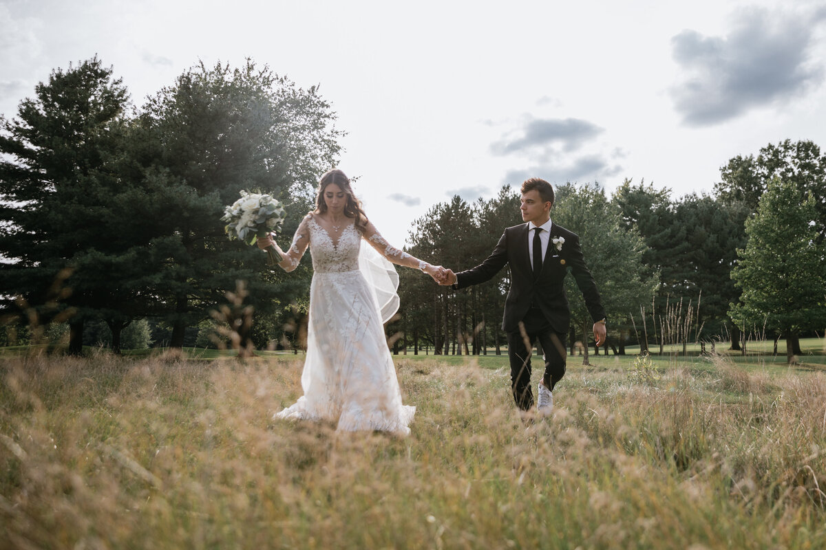 Couple runs through field after wedding