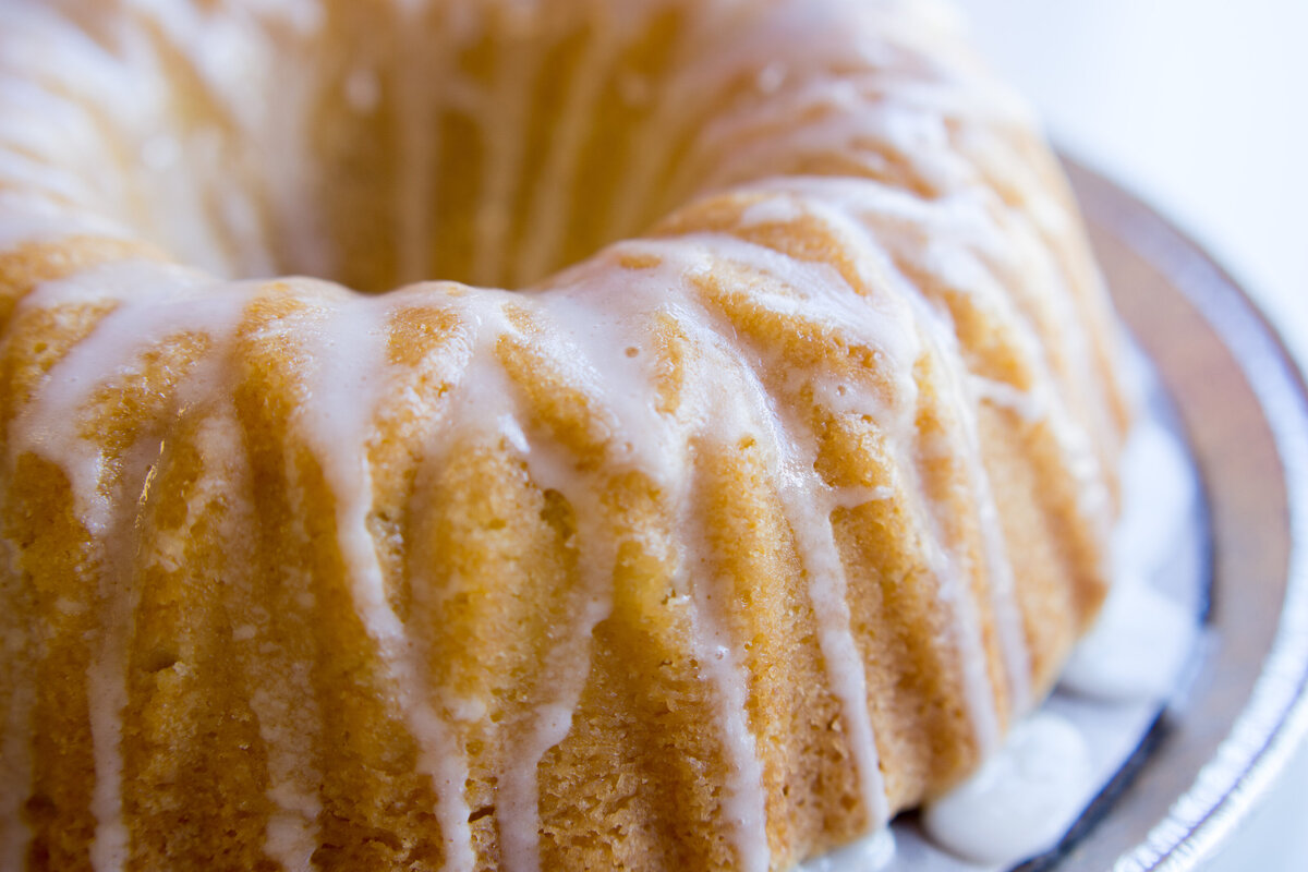 Closeup shot of a bundt cake with dripping icing on a silver pan
