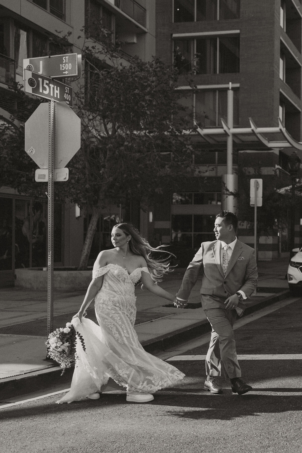 bride and groom crossing downtown street