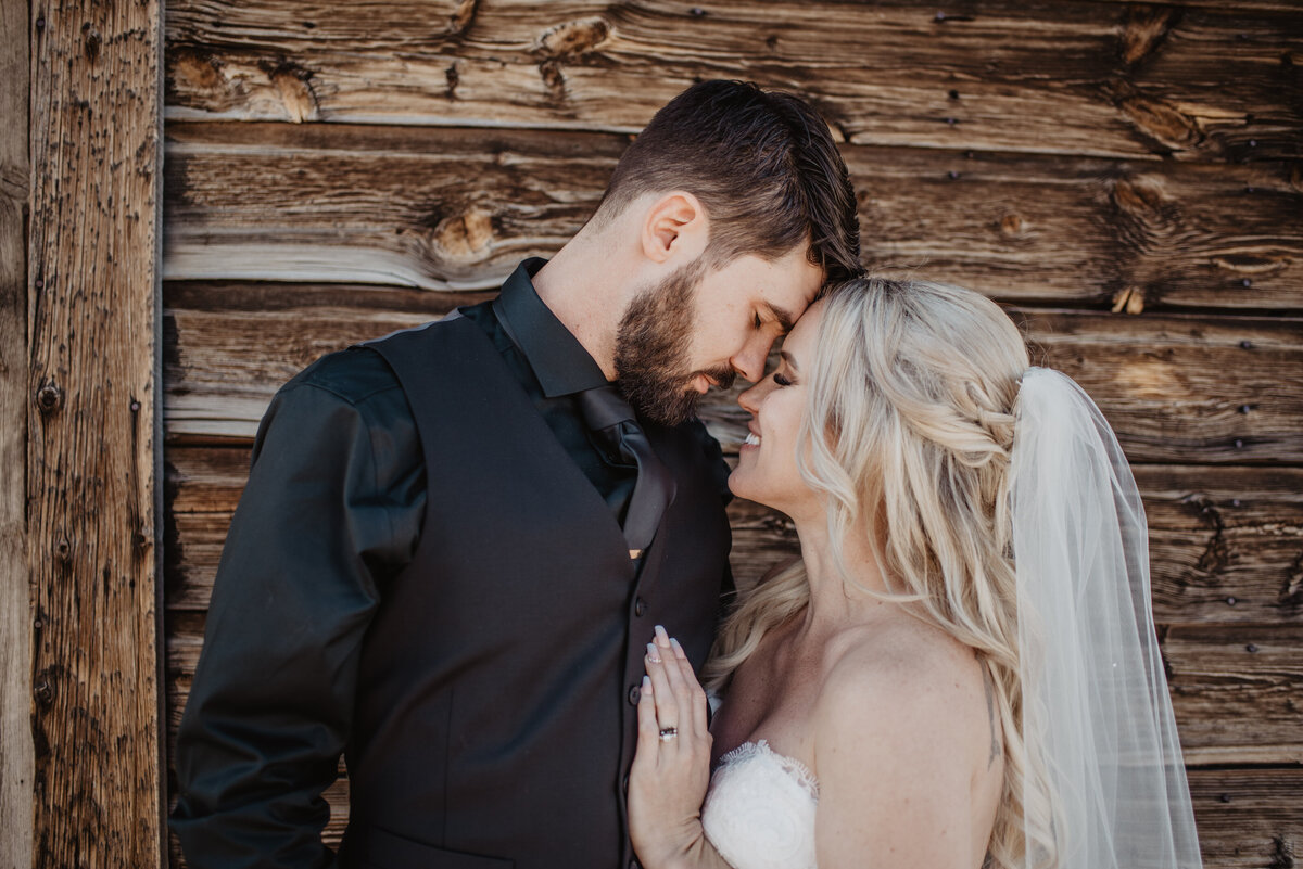 Jackson Hole Photographers capture bride and groom touching foreheads during portraits
