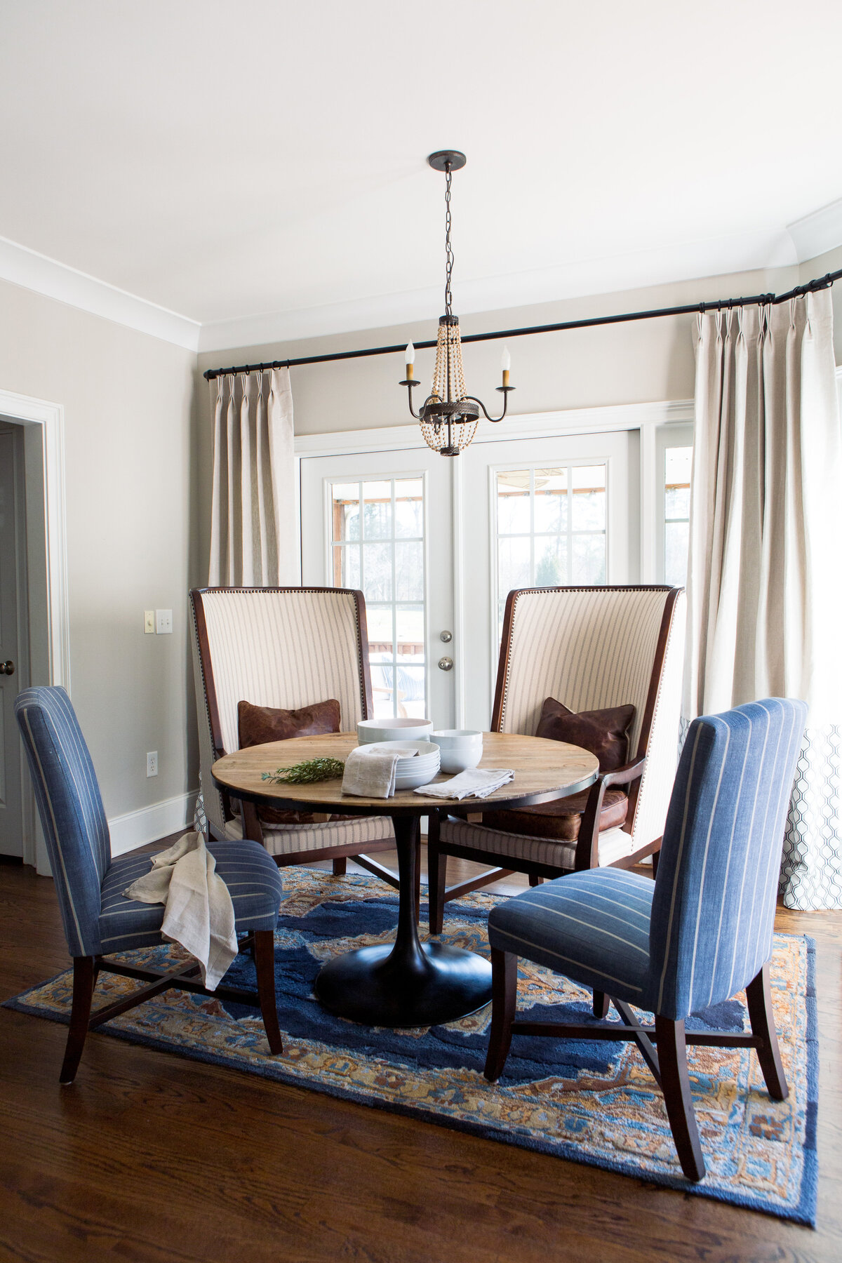 Sophisticated dining space in Lake Norman, NC, featuring blue upholstered chairs and a modern chandelier.