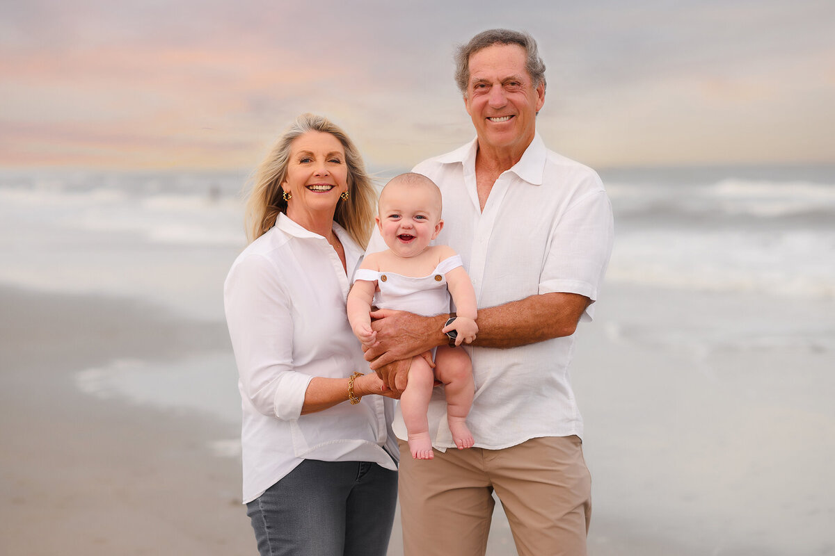 Grandparents embrace their infant grandson during Family Photoshoot on Isle of Palms. 