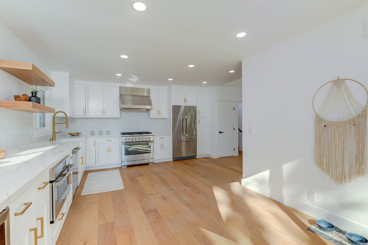 bright-kitchen-white-cabinets-wood-flooring-gold-fixtures