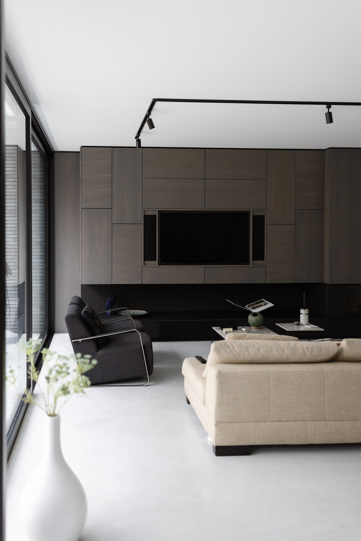 Een stijlvolle woonkamer met een op maat gemaakte kastenwand, die zowel functionaliteit als elegantie biedt.