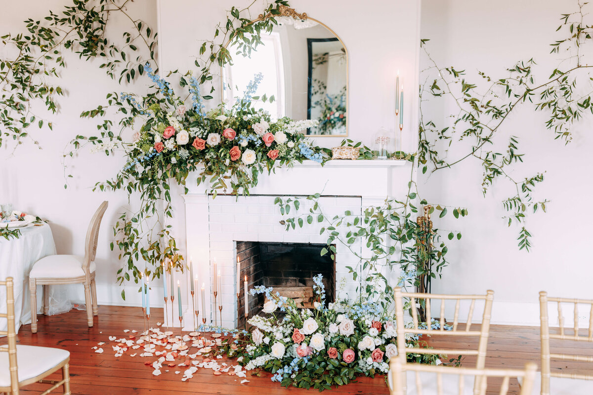 fireplace decorated with floral displays and greenery